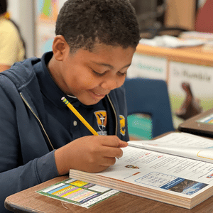 Student working at desk with smile