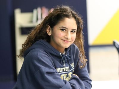 High school girl sitting at desk smiling