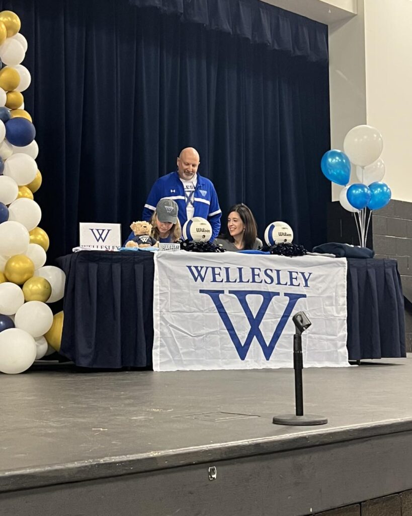 Emily signing at Wellesley to play college volleyball