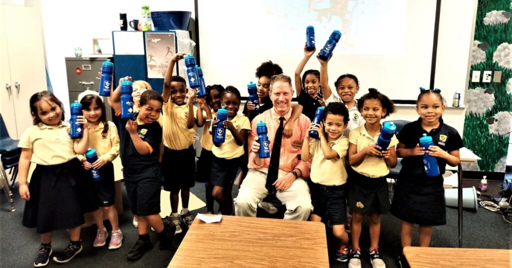 Coach Hawley with Kindergartners collecting change in their water bottles